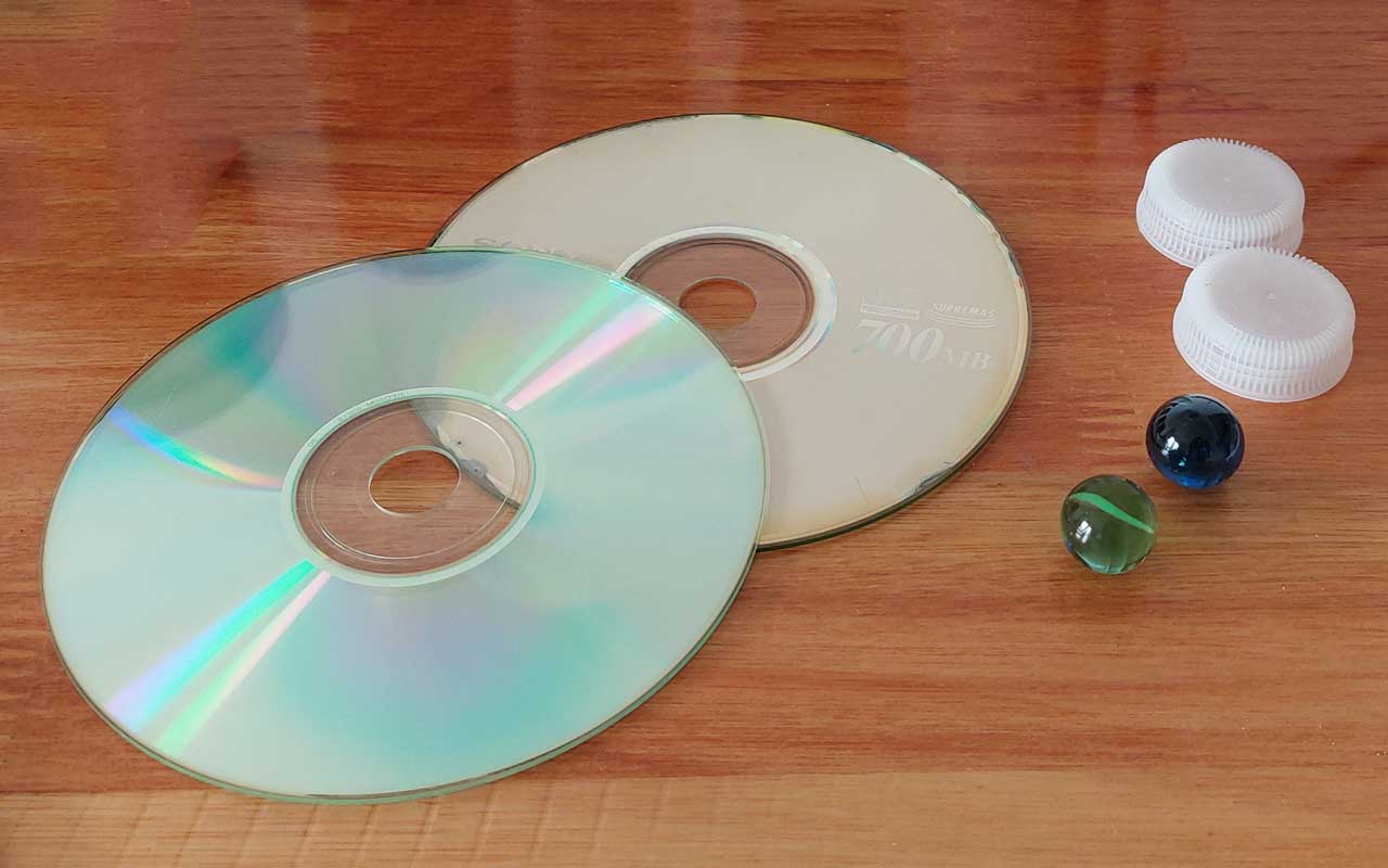 1. El tamaño estándar de las canicas es ideal para situar en el centro del CD y la tapita de gaseosa, para hacerlo girar.